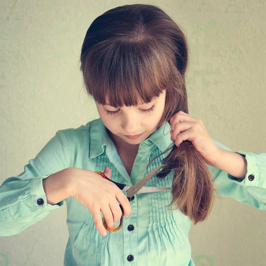 Little girl cut her hair. Toned image.