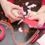 hands cutting paper for Pinterest Valentine's crafts