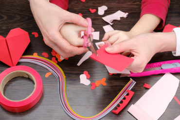 hands cutting paper for Pinterest Valentine's crafts