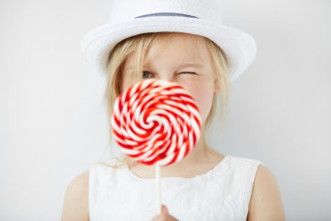 young girl with big spiral lollipop